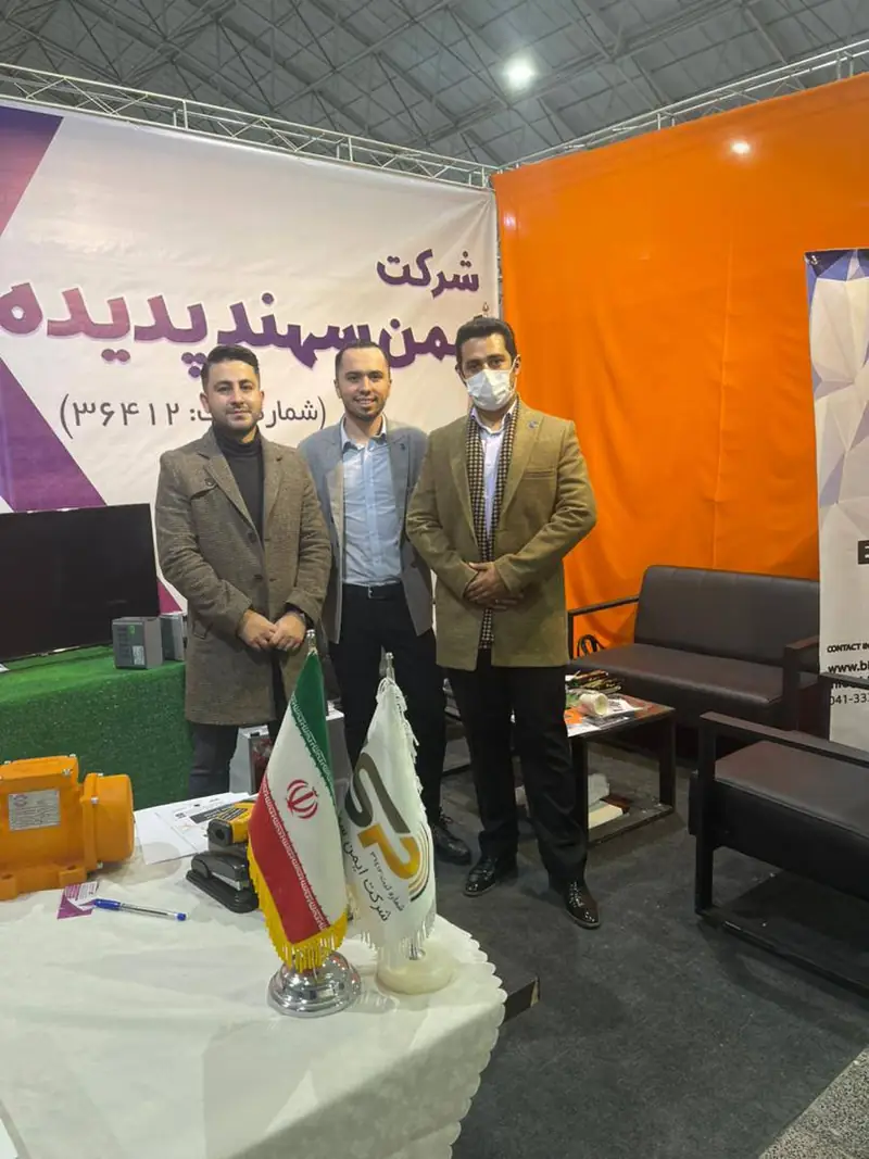 سه نفر در غرفه ایمن سهند پدیده با پرچم ایران